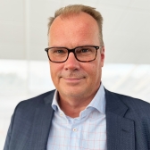 Porträtt av Mikael Lidström i mörkgrå kostym